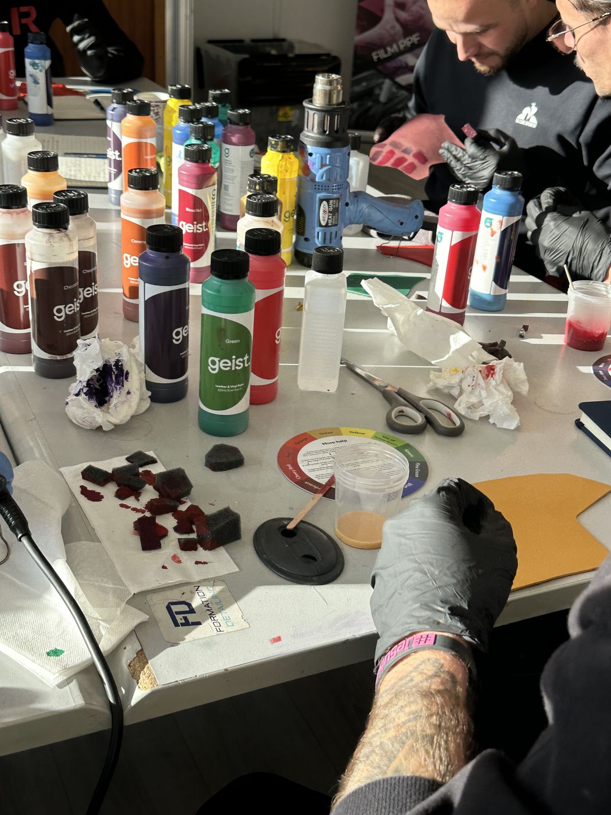 Flacons de pigments et éponges alignés sur la table de travail
