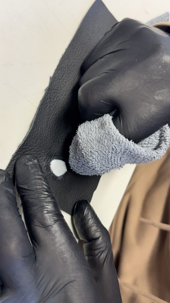 Réparation d’un trou dans le cuir avec gants noirs